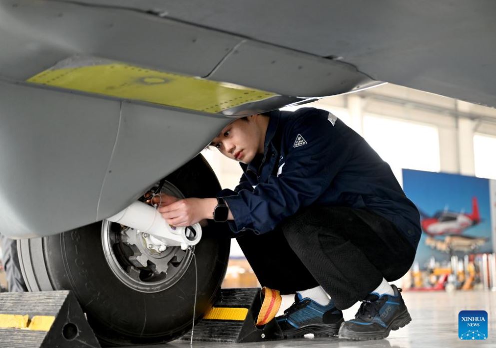 Zaposleni pregledujejo motorni sistem tovornega brezpilotnega letala (UAV) Changying-8 pred testnim poletom na letališču v Zhengzhouju v provinci Henan v osrednji Kitajski, 30. marca 2026.