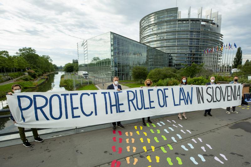 Janšo pred Evropskim parlamentom pričakali s transparentom, slikami nasilja in opozorili o represiji v Sloveniji