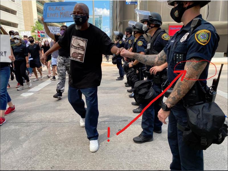 Med protesti v Houstonu posnet policist s tetoviranimi rokami, med ostalimi se lepo vidi napis »RUSIJA«