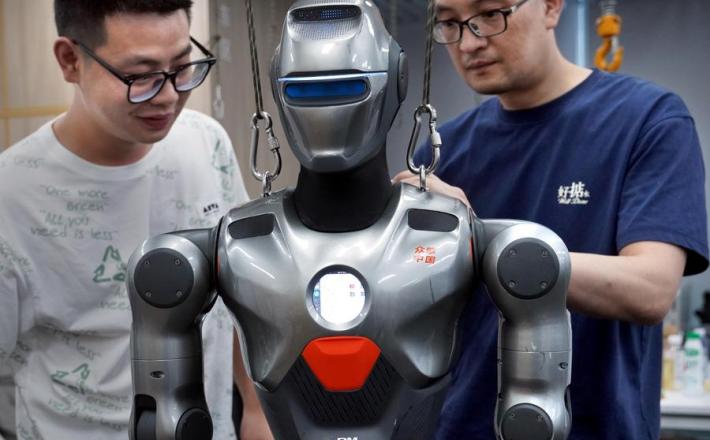 Guangdong, 25. 6. 2025: Strokovnjaka odpravljata napake na robotu (Xinhua/Li An)