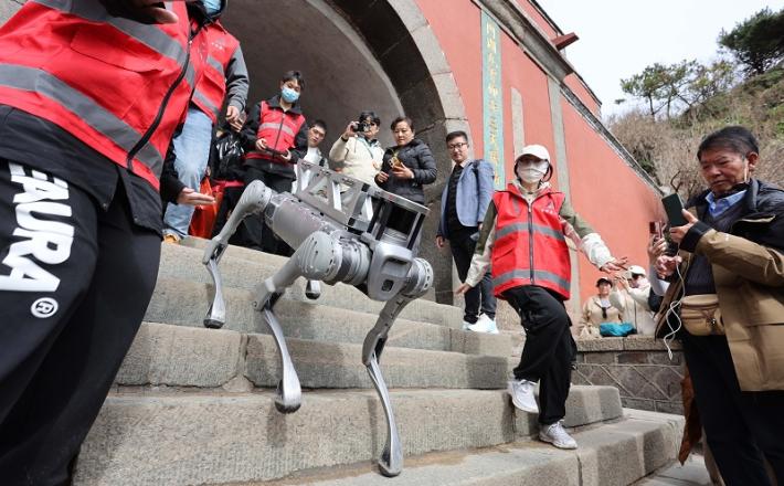 Testno osebje preizkuša robotskega psa  (Fotografija Sui Xiang/Xinhua)